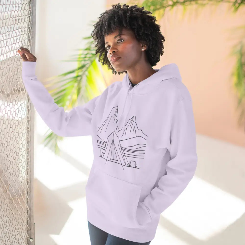 Woman wearing white unisex hoodie with mountain and camping tent line art, cozy fleece