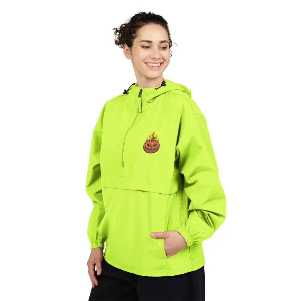 Woman wearing lime green champion packable anorak jacket with flaming pumpkin graphic