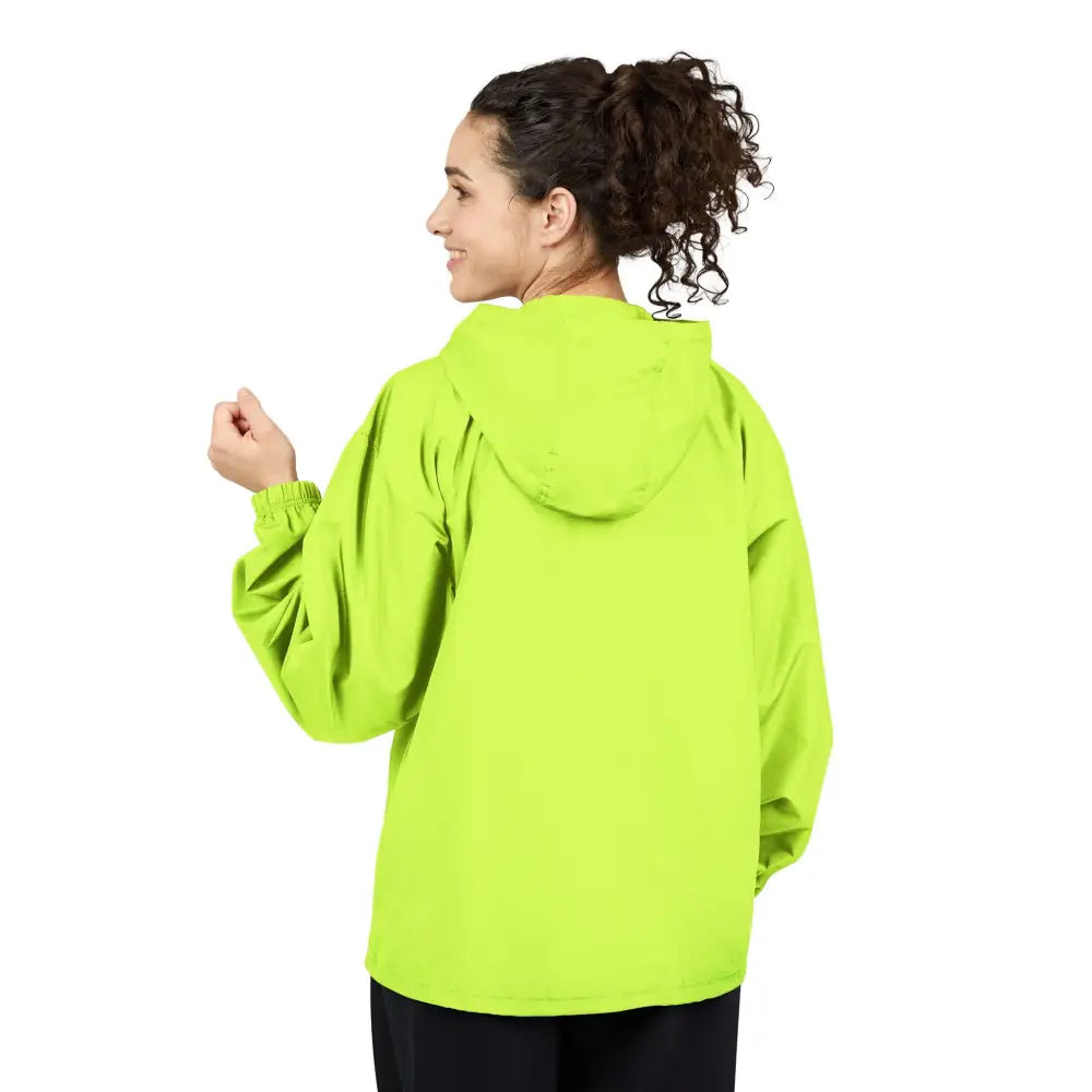 A person wearing a bright green Champion Packable Anorak jacket with flaming pumpkin design