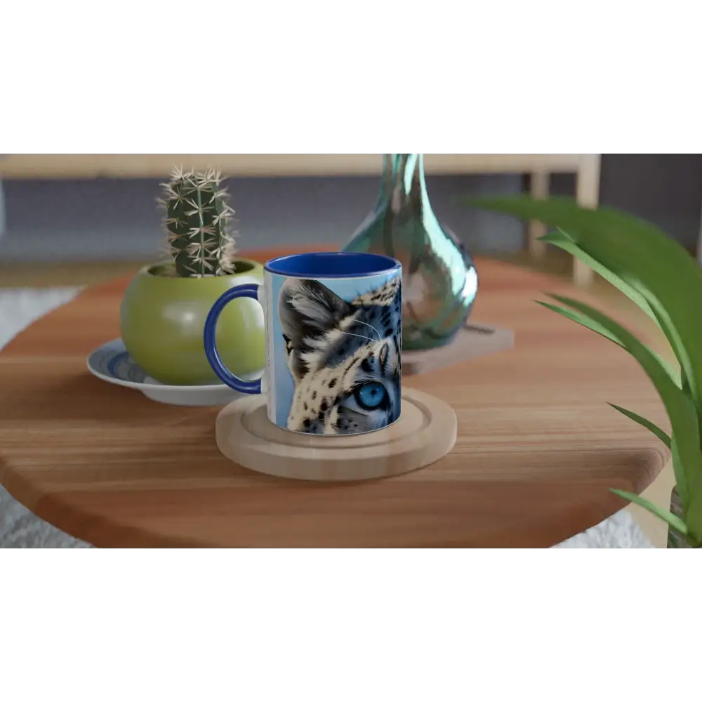 Blue-handled ceramic mug featuring a snow leopard image from PixiOnyx Glacier Gaze collection