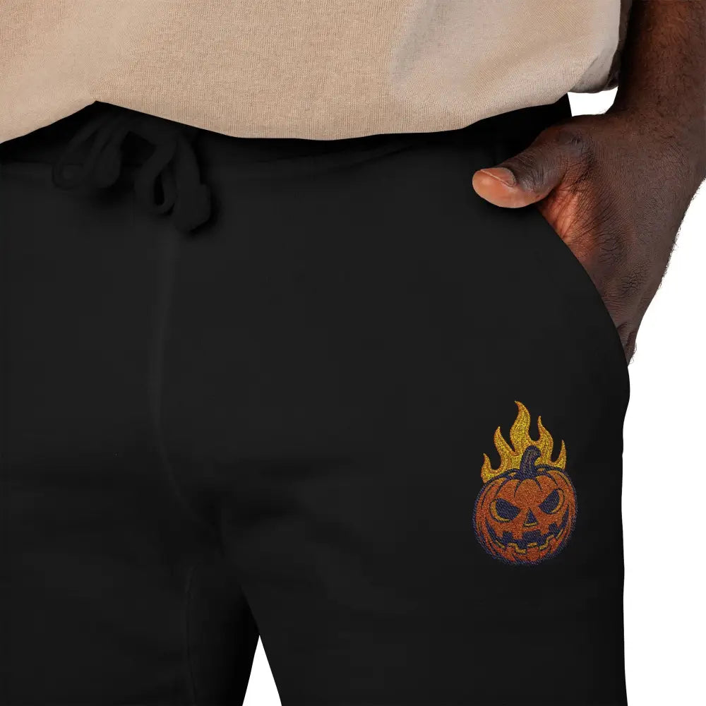 Black fleece sweatpants with flaming pumpkin embroidery for cozy Halloween streetwear