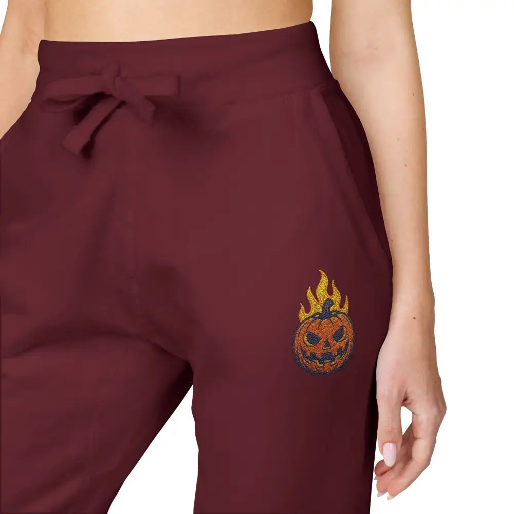 Maroon fleece sweatpants with flaming pumpkin design for cozy Halloween streetwear