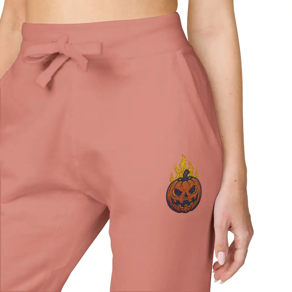 Pink women’s fleece sweatpants with flaming pumpkin design for cozy Halloween streetwear