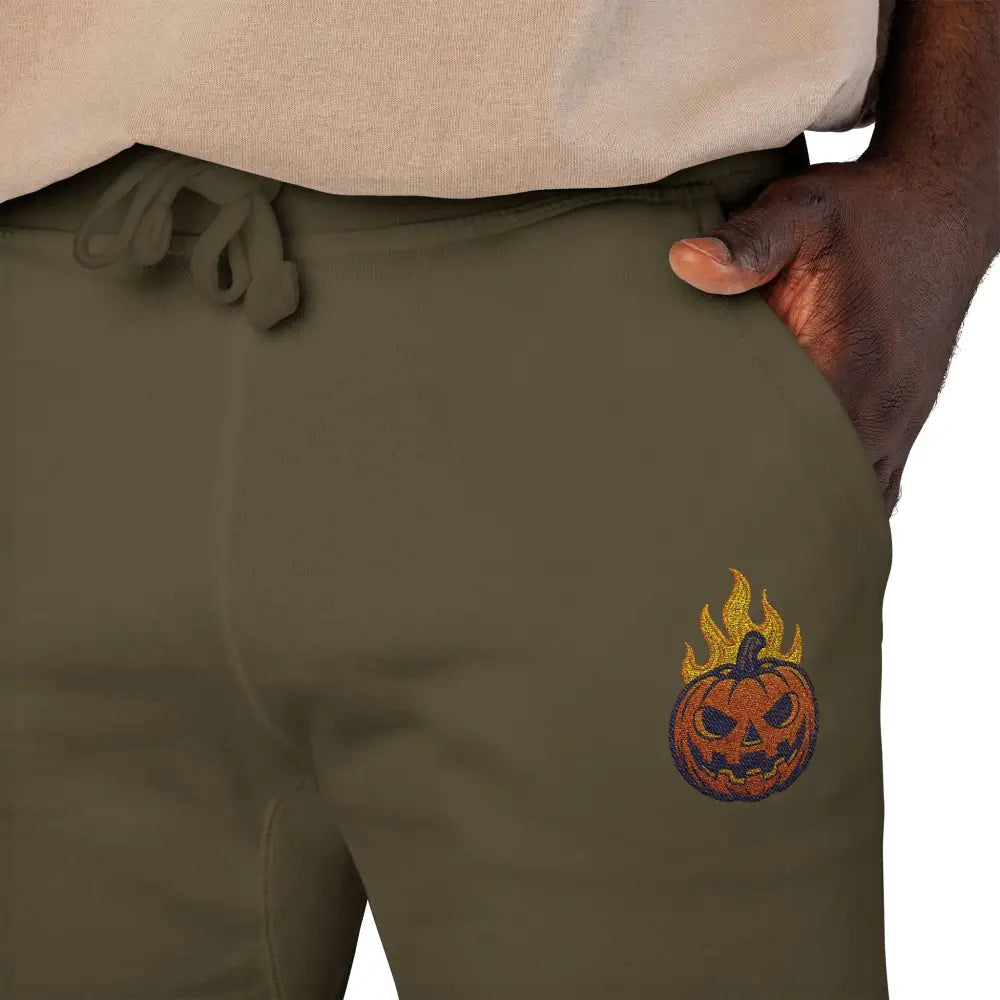 Olive green fleece sweatpants with flaming pumpkin design for cozy Halloween streetwear