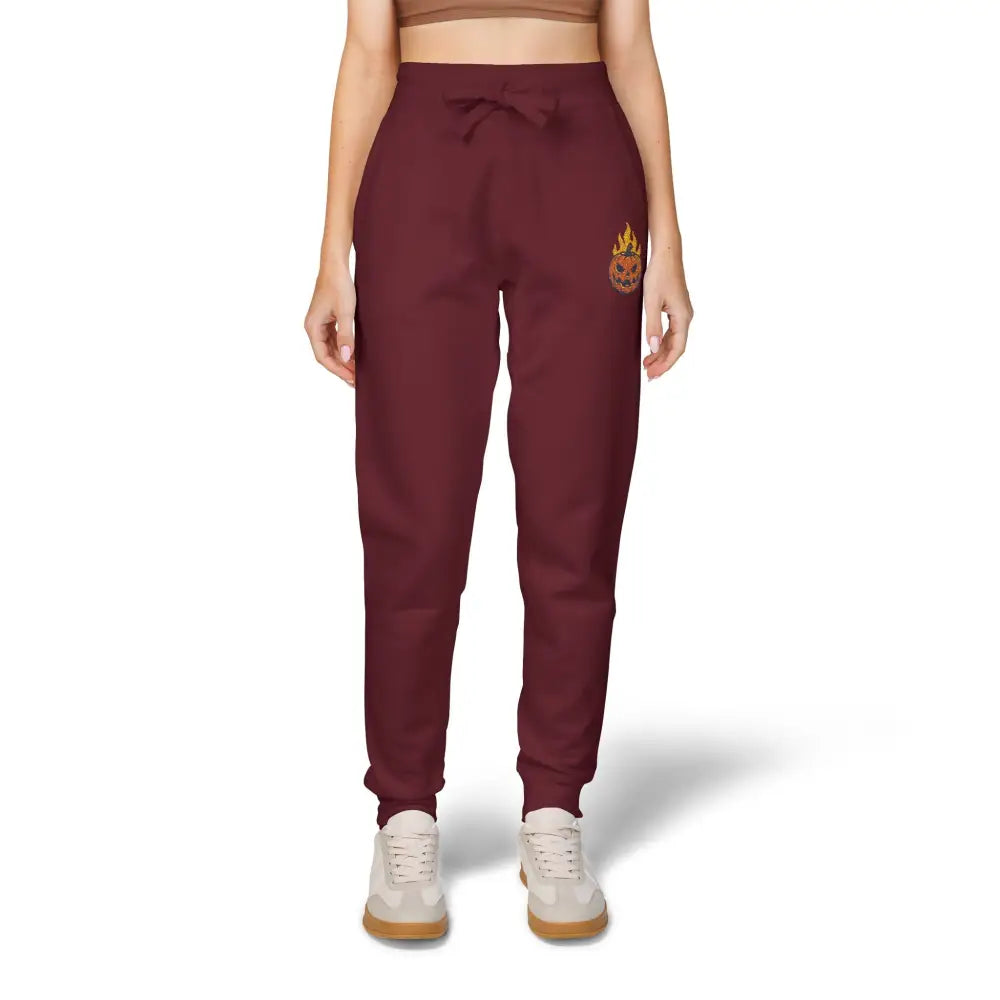Maroon fleece sweatpants with flaming pumpkin design on right leg, cozy Halloween streetwear