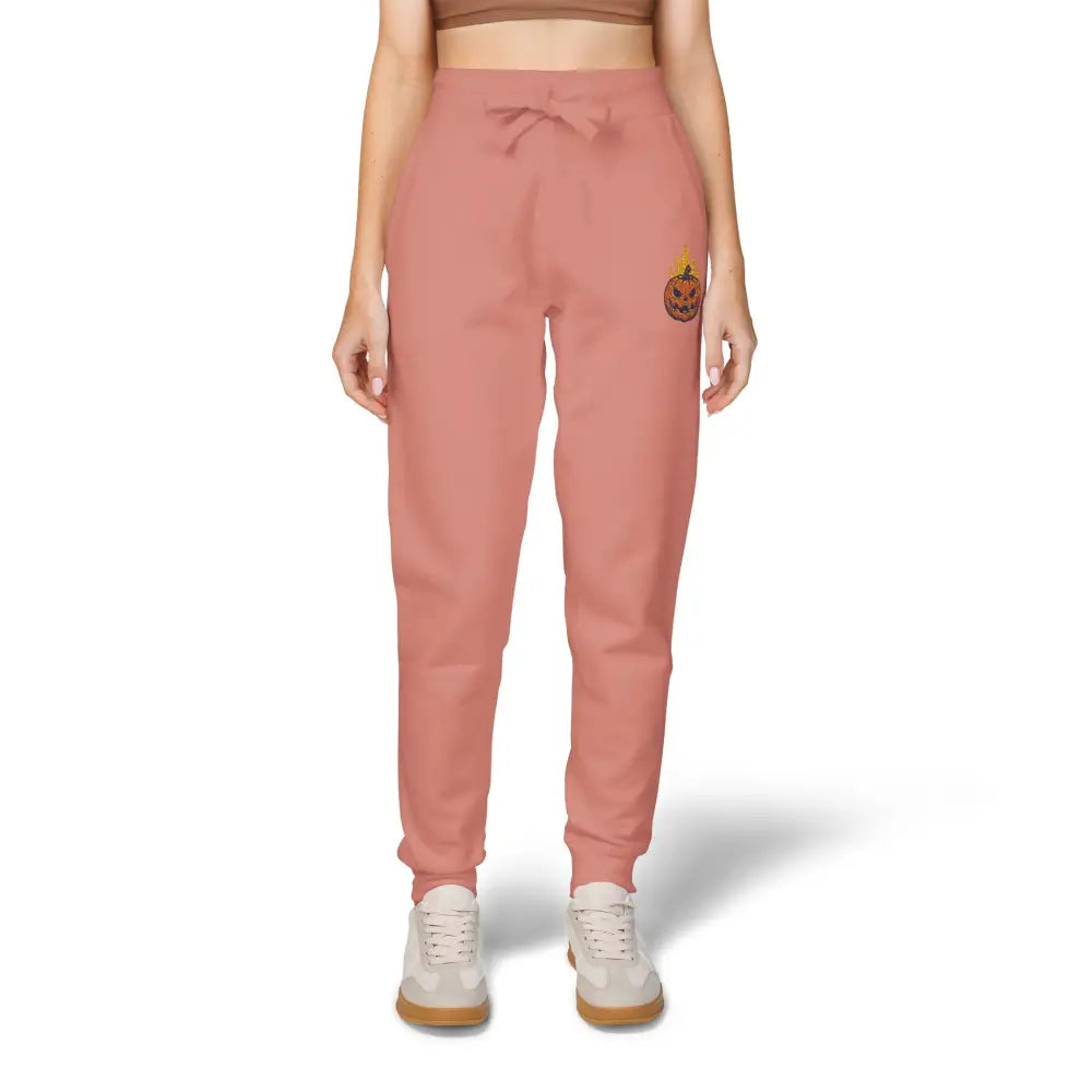 Women’s salmon pink fleece sweatpants with flaming pumpkin graphic on left thigh for cozy Halloween style