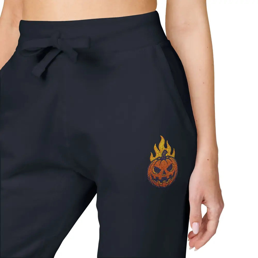 Black fleece sweatpants with flaming pumpkin design for cozy Halloween streetwear