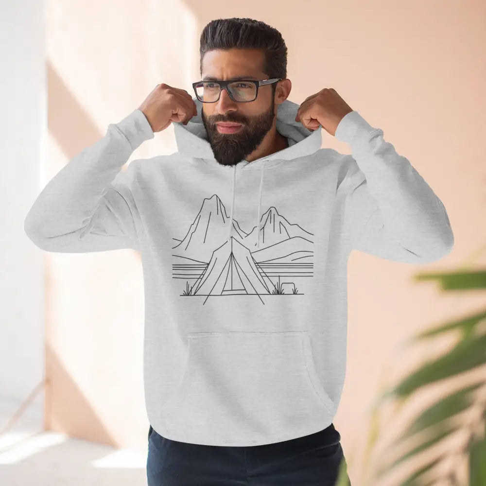 Man in white hoodie with black camping design showcasing unisex hoodie with luxurious fleece