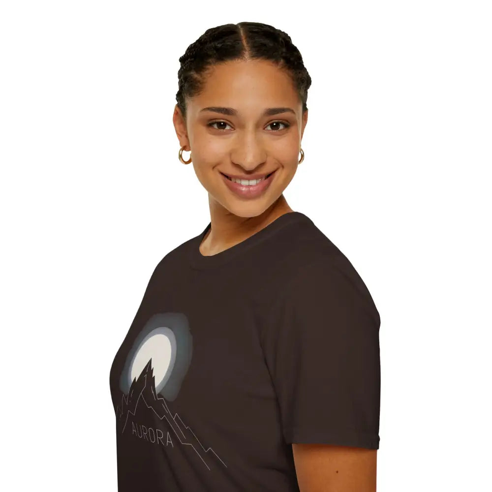Young woman wearing Aurora Mountain Unisex Softstyle T-Shirt with mountain and moon graphic