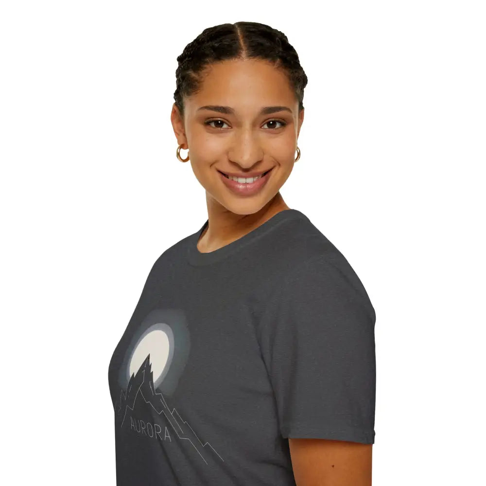 Woman wearing Aurora Mountain Unisex Softstyle T-Shirt with moon and mountain graphic