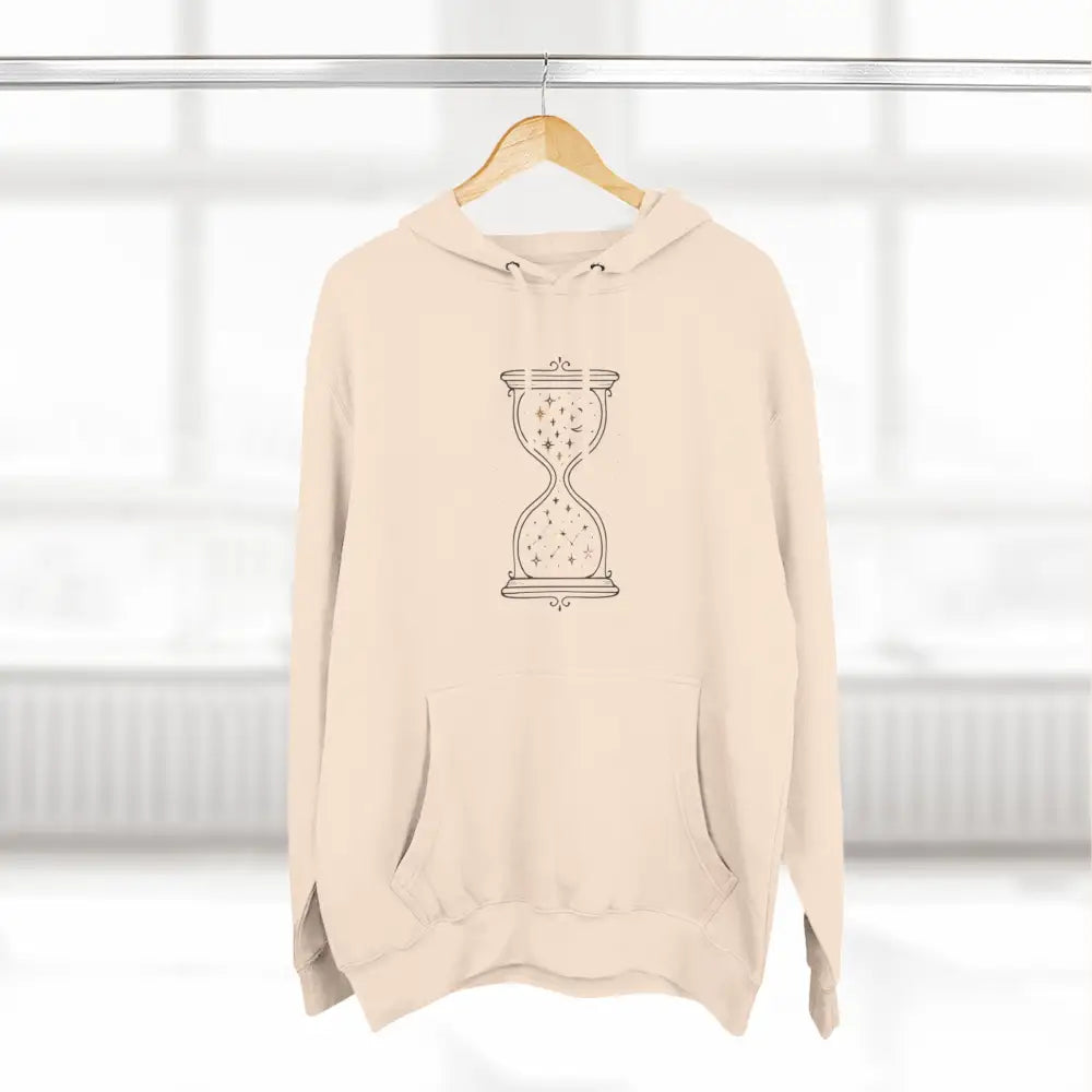Light beige fleece hoodie with black star-filled hourglass design, easy care instructions