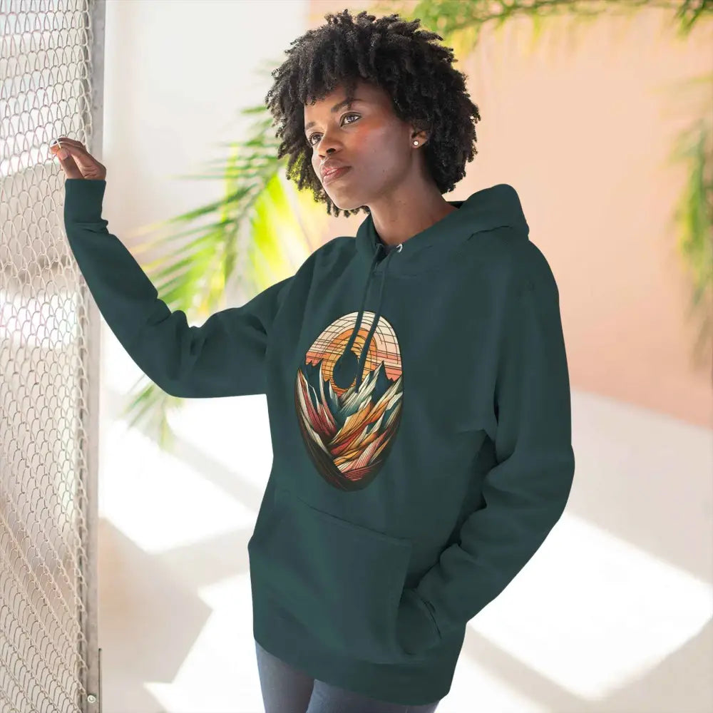 Woman in dark green three-panel fleece hoodie with colorful graphic print and kangaroo pouch