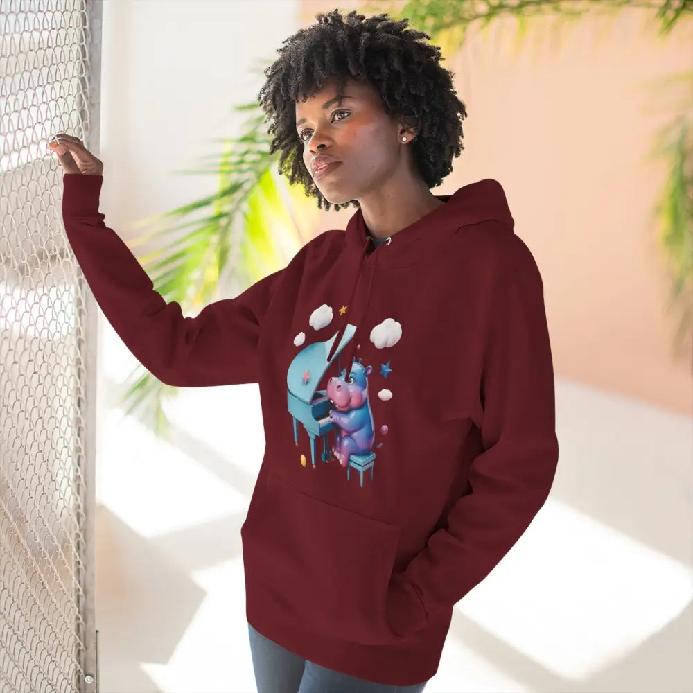 Woman in maroon fleece hoodie with cute hippopotamus playing a light blue grand piano