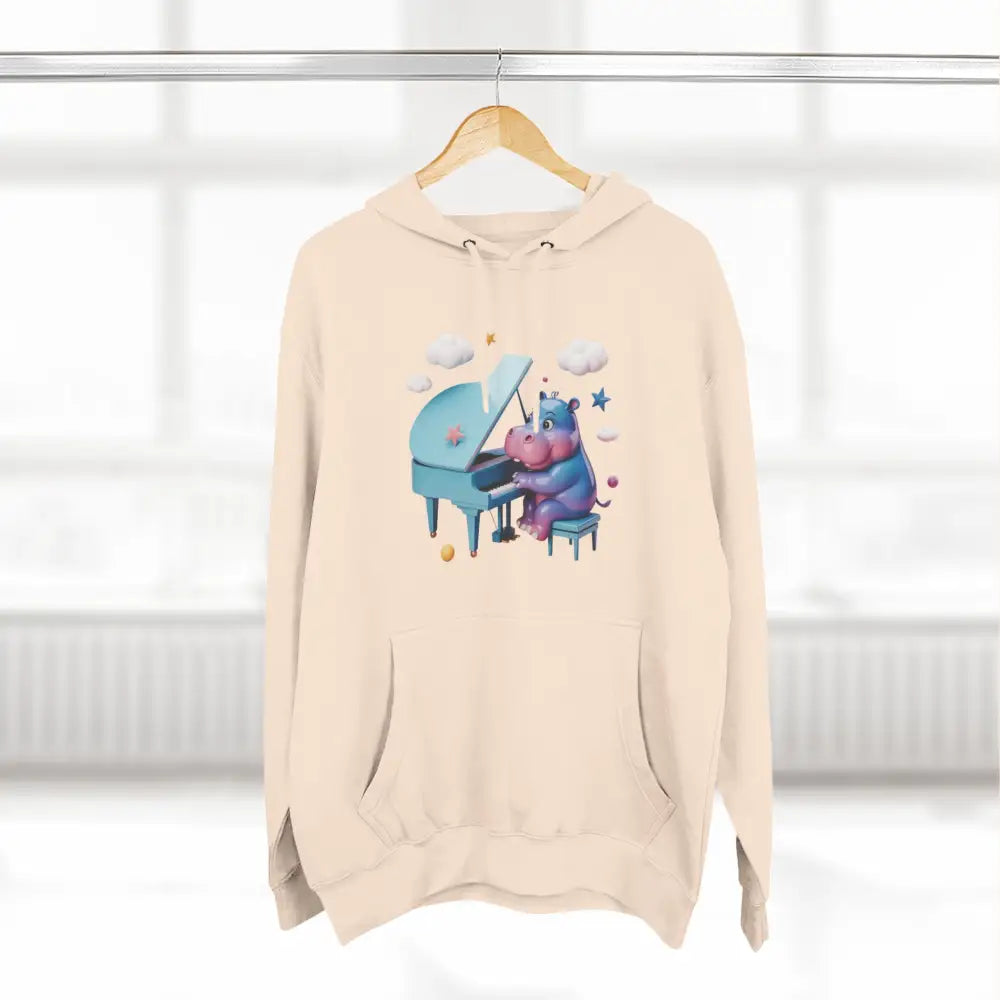 Light cream-colored fleece hoodie with a playful cartoon hippo playing piano, perfect for kids and teens