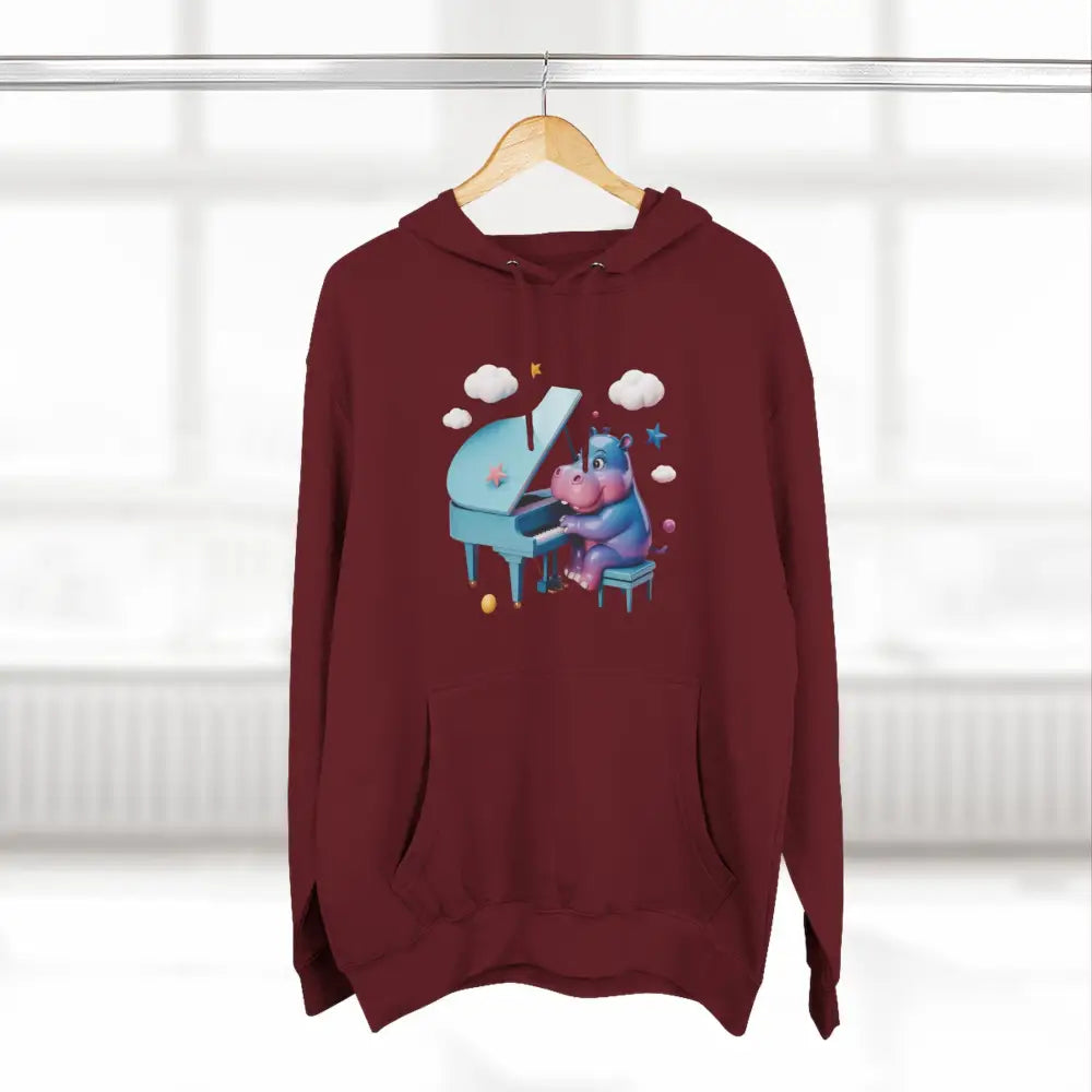 Maroon fleece hoodie with a cartoon hippo playing a light blue grand piano, perfect for music lovers