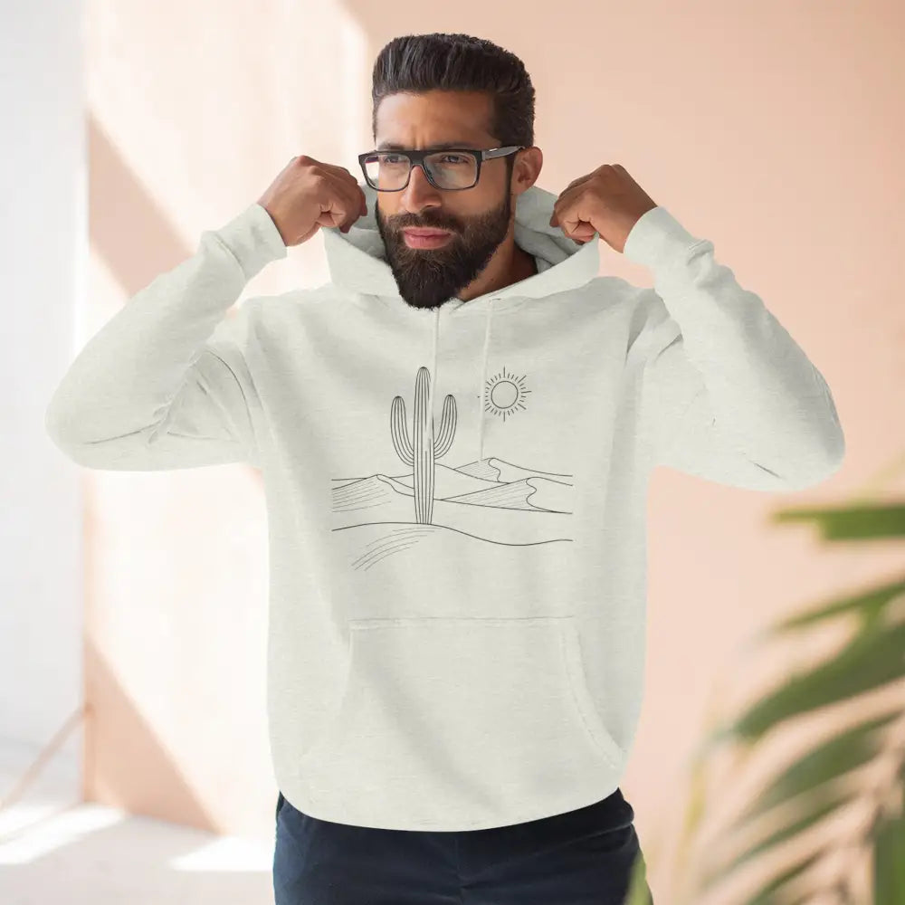 Man wearing a cream-colored three-panel fleece hoodie with desert sun and saguaro cactus graphic