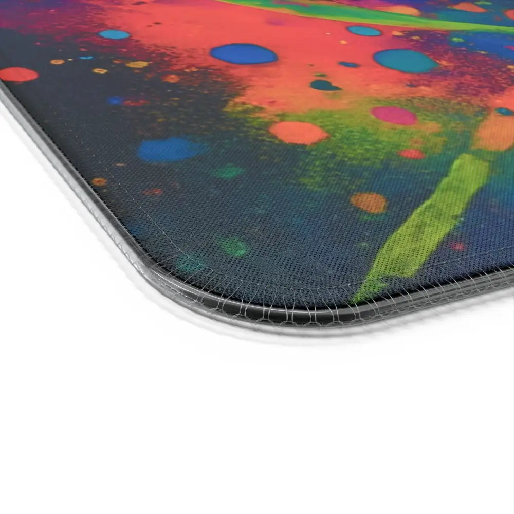 Colorful splatter-patterned LED gaming mouse pad with psychedelic skull glow design