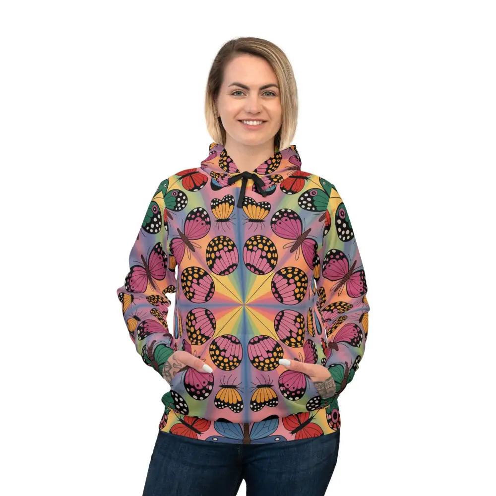 Woman wearing a Kaleidoscope Flight unisex hoodie with colorful butterfly pattern for athletic versatility