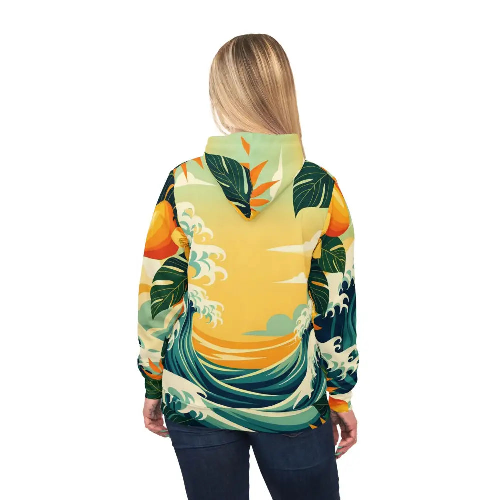 Woman wearing a tropical wave-patterned unisex hoodie from PixiOnyx Mango Coastwear